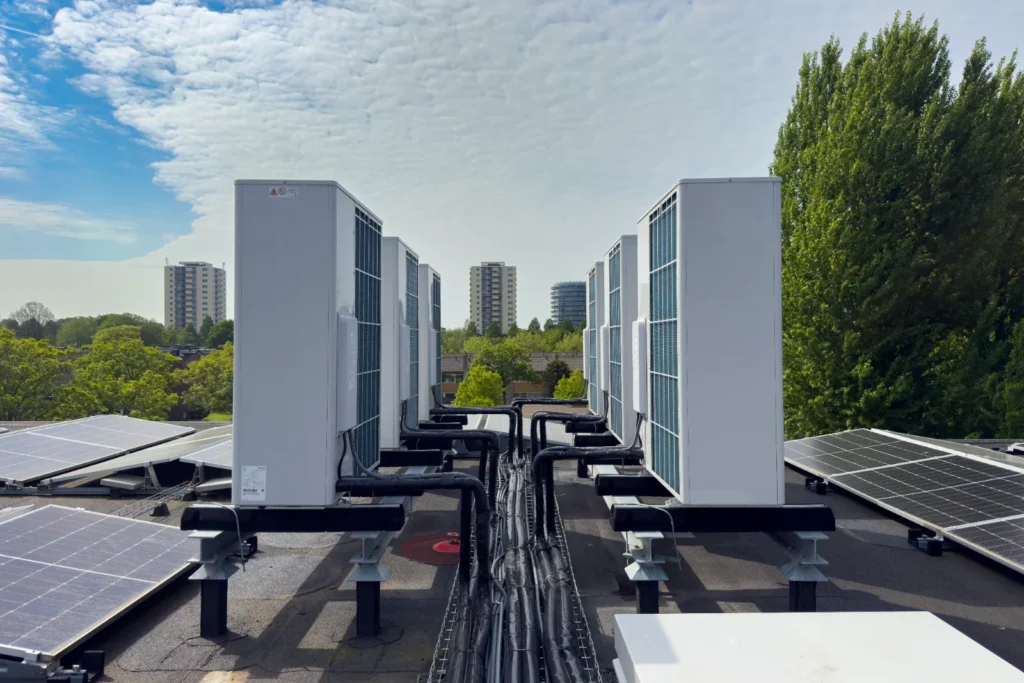 Twee rijen buitenunits met de gekoppelde leidingen ertussen.