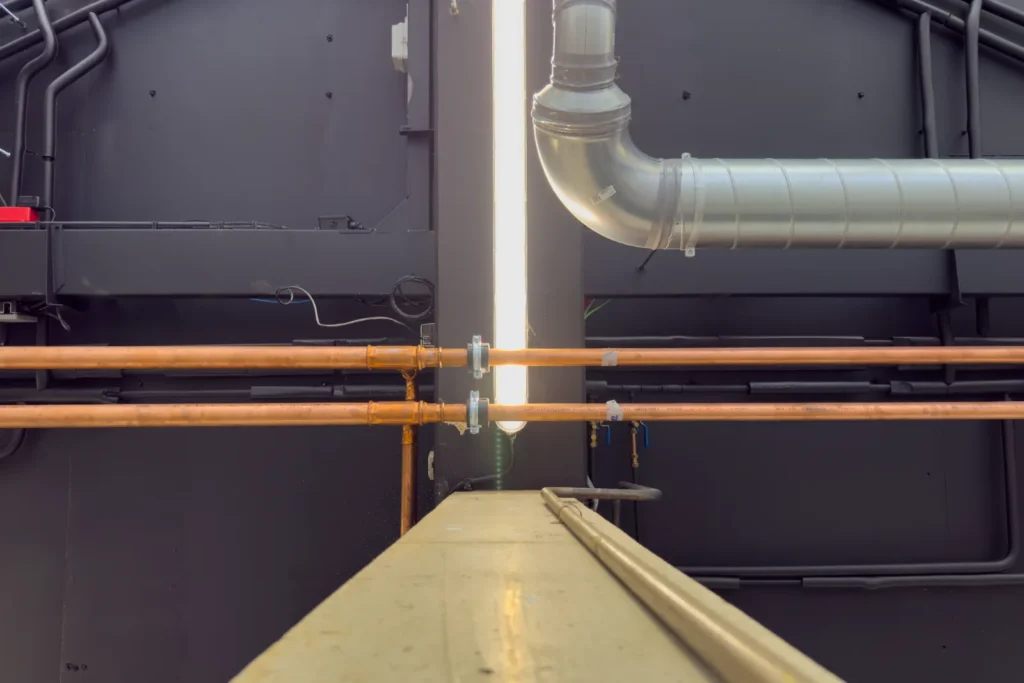 Netjes uitgelijnd koperwerk langs de kanaalinstallatie.